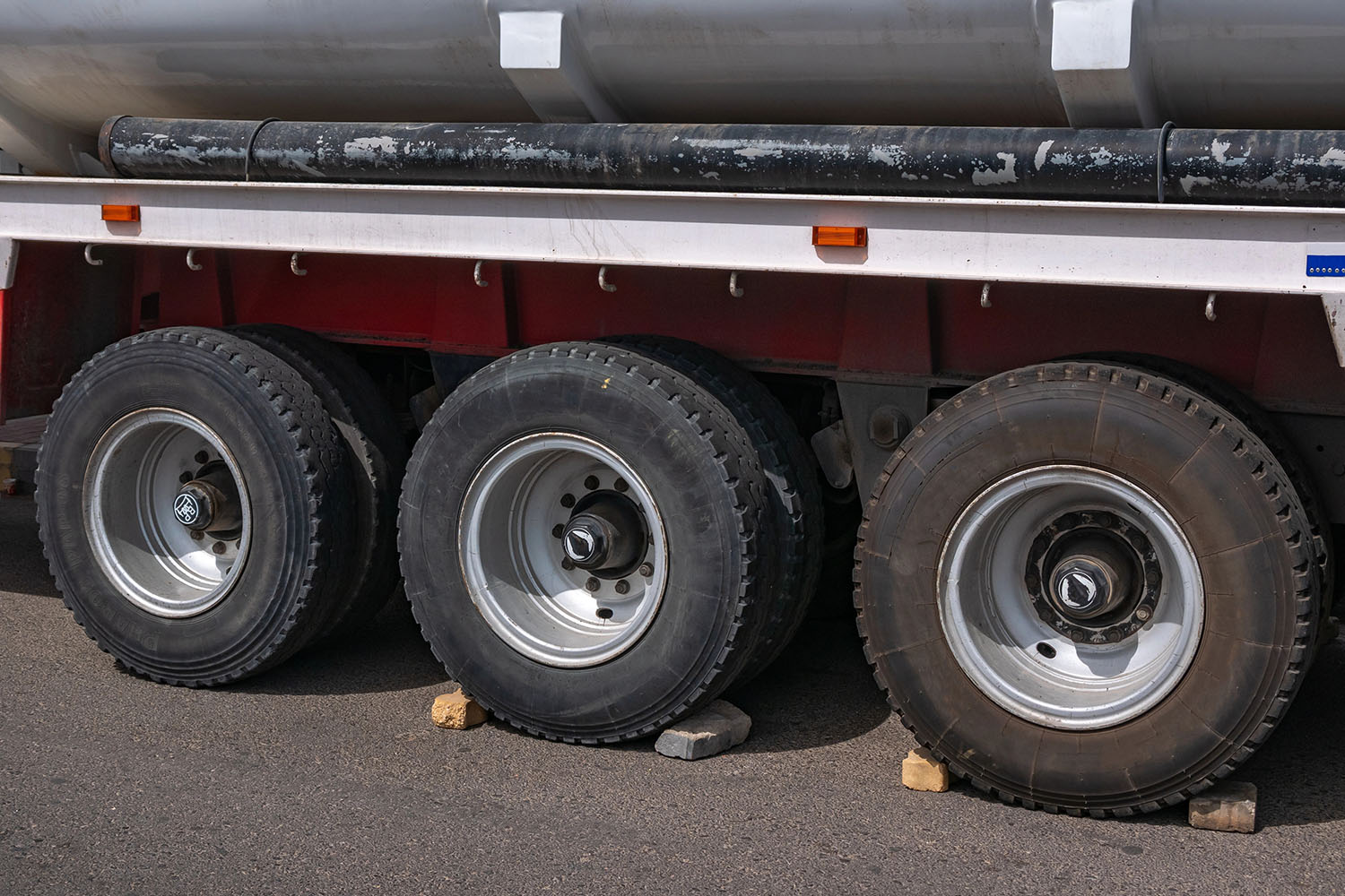Close-up of three big black wheels on a truck trailer.